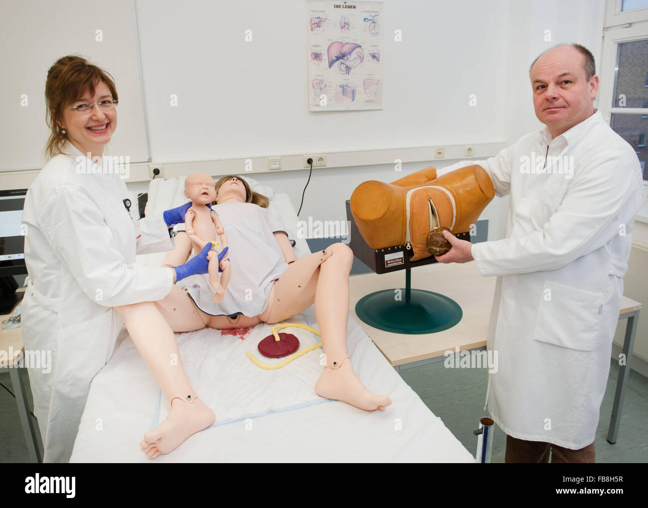 Gynecologist Katja Bartz and Marek Zygmunt, director of the Greiswald Hospital for Obstetrics and Gynaecology, demonstrate the birth of a child on a female full body childbirth simulator and on a birth model that has been in operation so far in the training center of the Greifswald University Hospital in Greifswald, Germany, 07 January 2016. Regular childbirths as well as major birth complications can be trained with the 'SimMom' (Simulation mother). The birth simulator costs approximately 60.000 Euros and is supposed to make the medical training more practical. Photo: Stefan Sauer/dpa Stock Photo