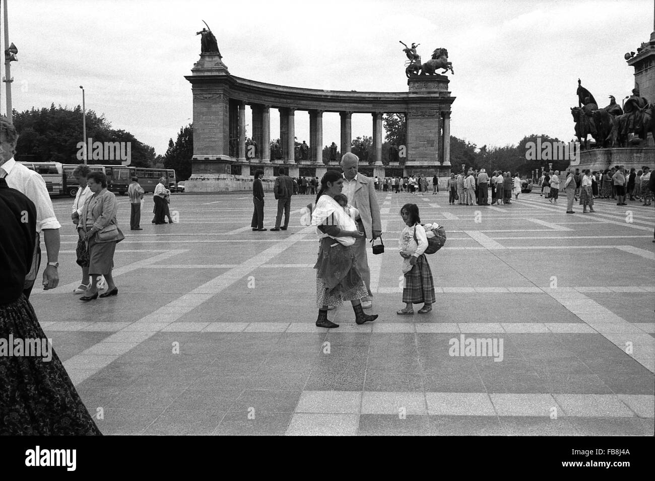 Glance on Bupapest at the time of the Nineties. -  1990  -  Hungary / Budapest  -  Glance on Bupapest at the time of the Nineties. -  Tourists and Hungarian inhabitants walking on the famous and huge square called 'Hosok Tere' ('Heroes' Square'). - We can observe one of the two peristyles of the 'Millenium Monument' and the entrance of the Musueum of Fine Arts at the right.   -  Philippe Gras / Le Pictorium Stock Photo