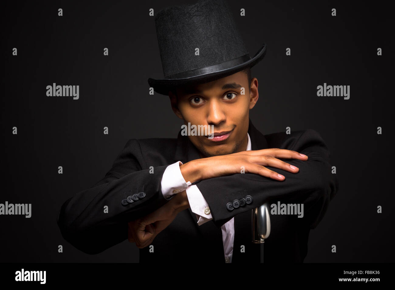 Handsome man in top hat posing with cane Stock Photo