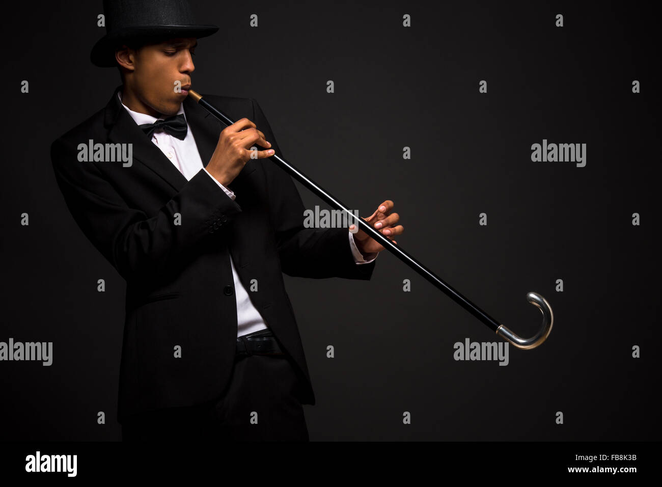 Handsome man in top hat posing with cane Stock Photo