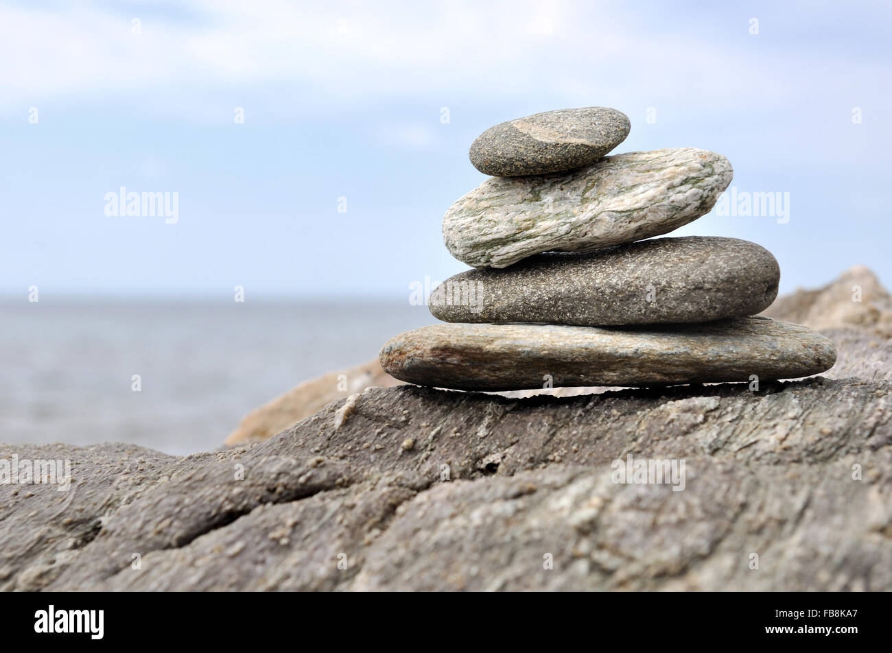 pebbles piled on rocks  on the seafront Stock Photo