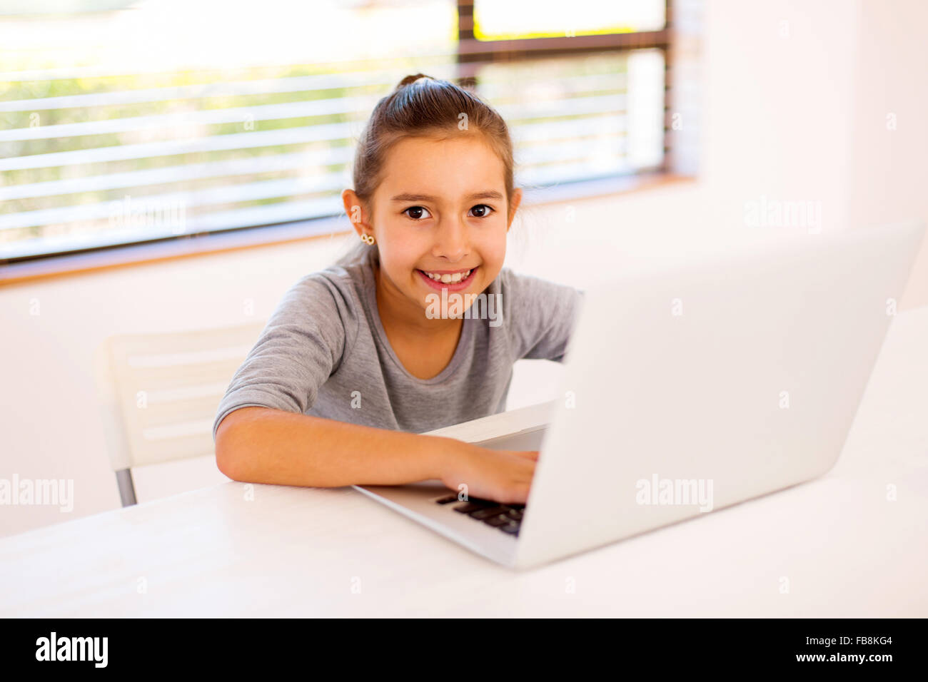 pretty little girl using laptop at home Stock Photo - Alamy