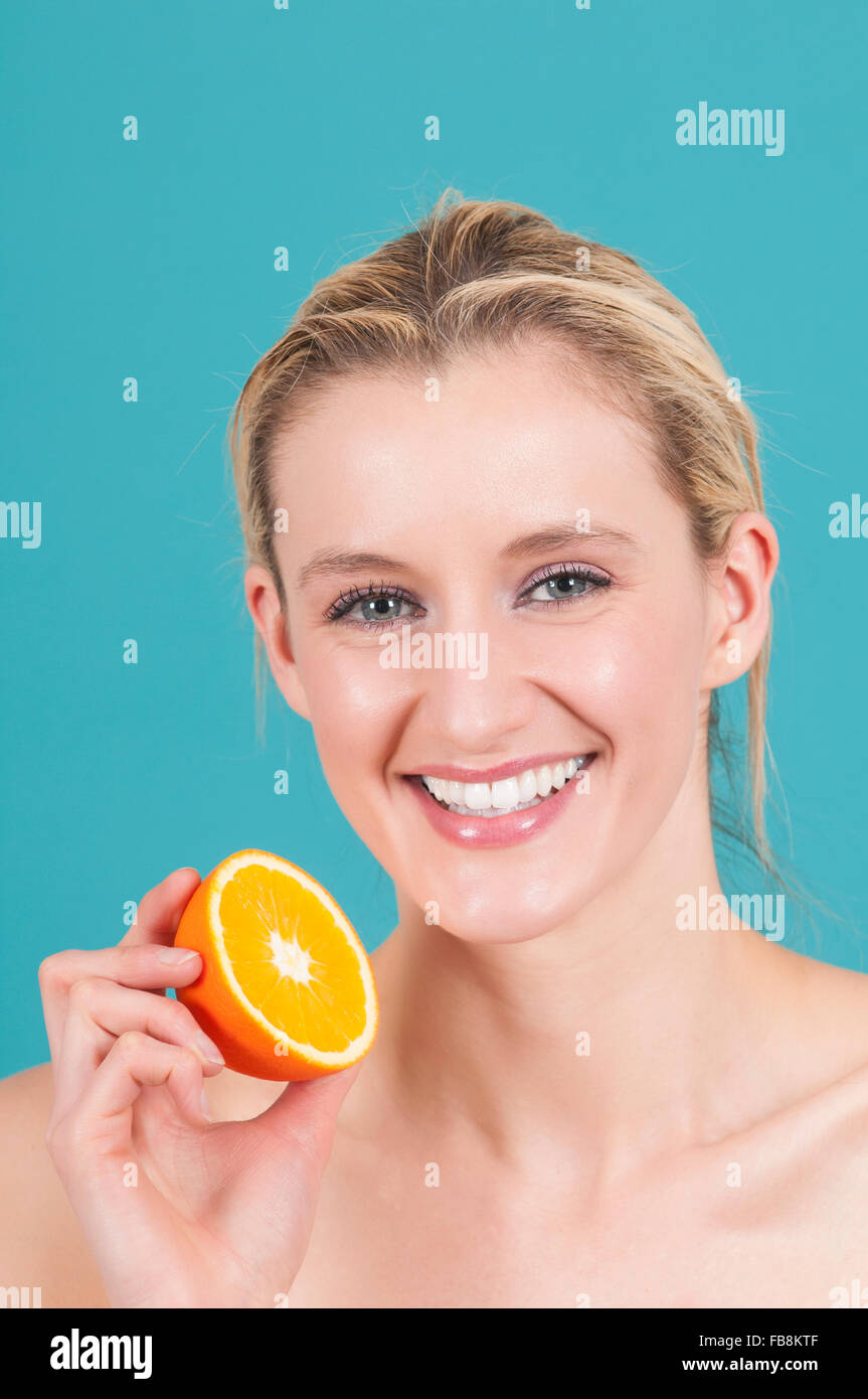 Healthy woman holding orange fruit Stock Photo - Alamy