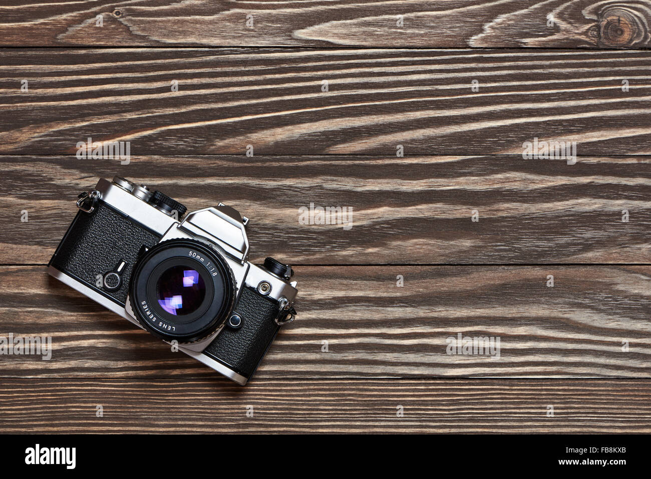 Retro SLR camera on old wooden background Stock Photo