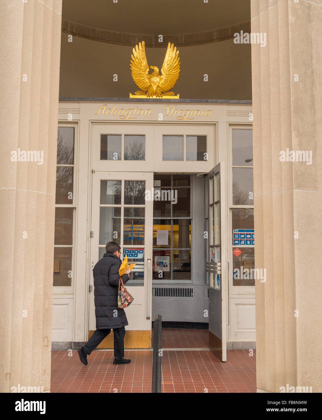 ARLINGTON, VIRGINIA, USA - Woman entering U.S. Post Office, and gold leaf eagle and name over door. in Clarendon neighborhood. Stock Photo