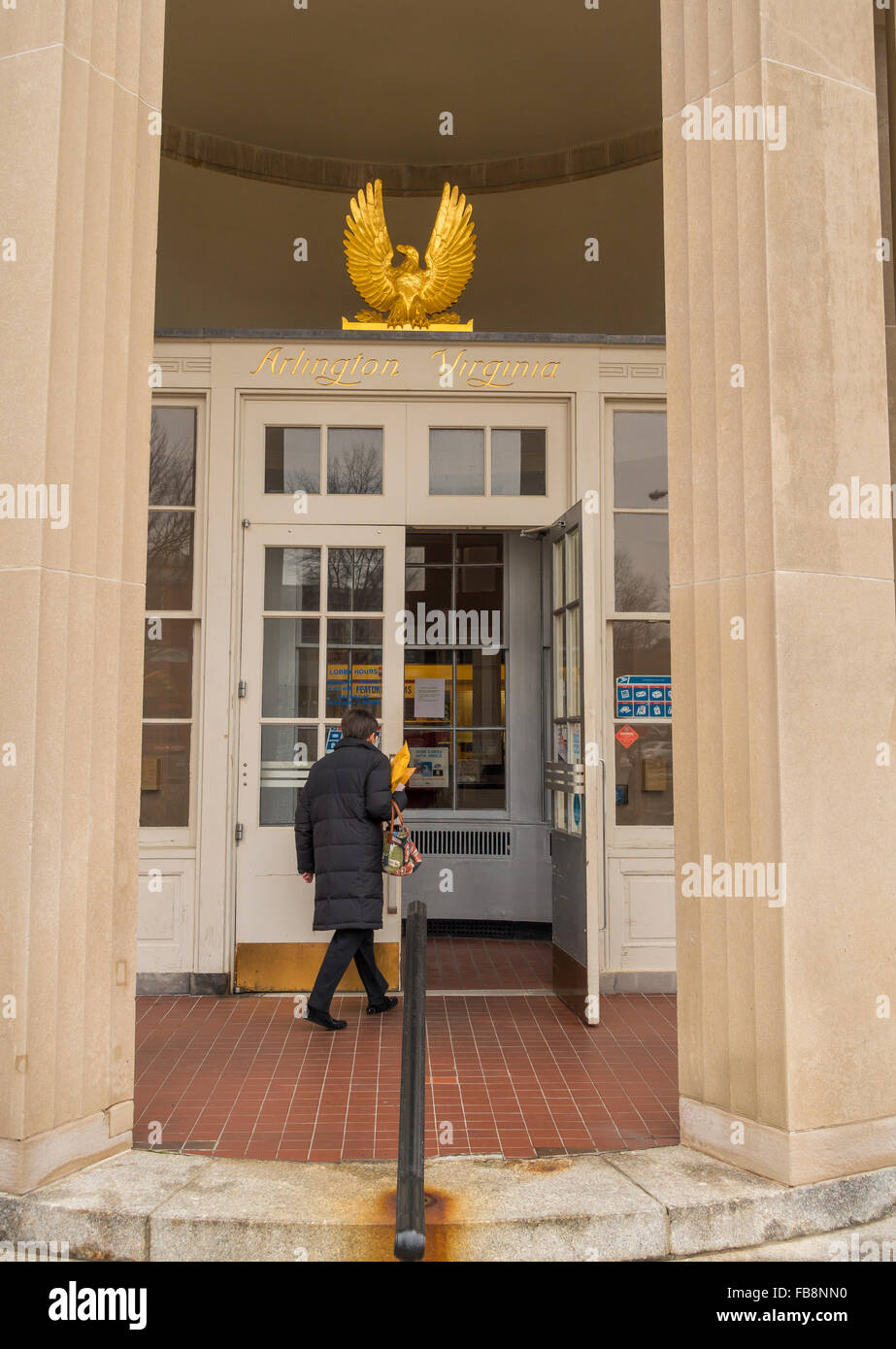ARLINGTON, VIRGINIA, USA - Woman entering U.S. Post Office, and gold leaf eagle and name over door. in Clarendon neighborhood. Stock Photo