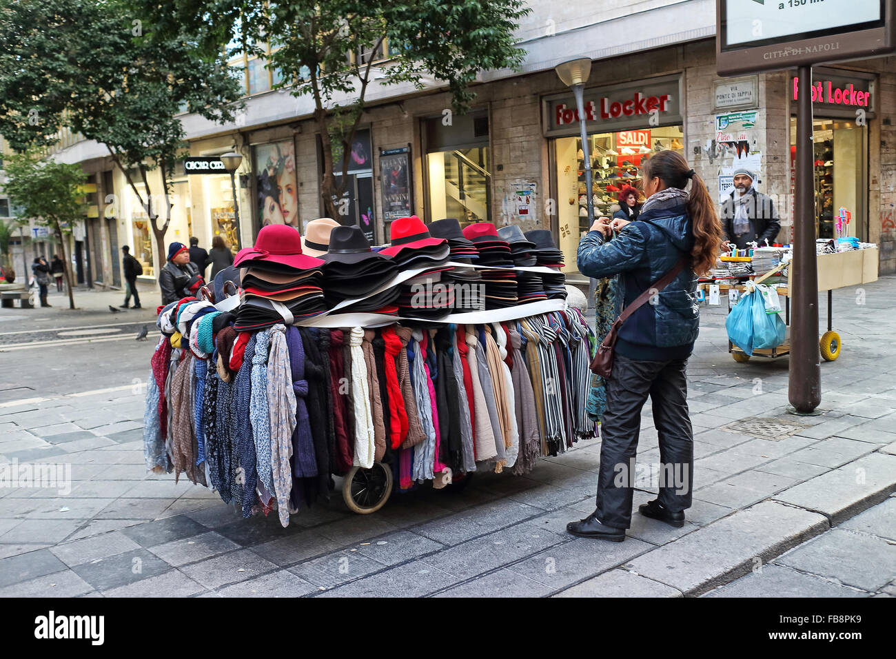 Naples, Italy - January 6, 2016: in a main street of the historic city center, a street vendor of hats with his cart. Stock Photo
