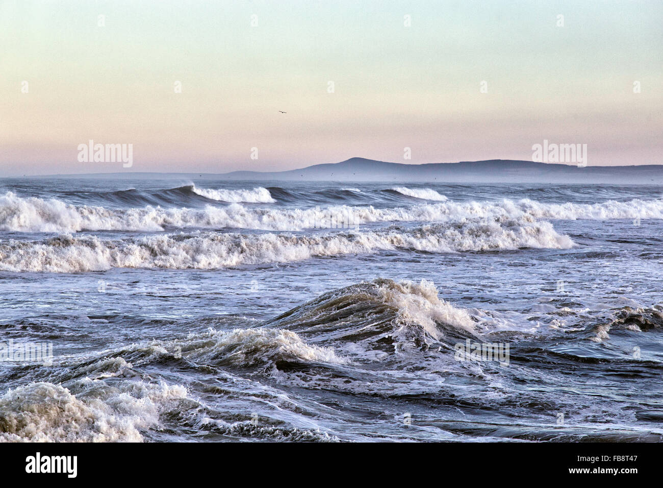 Breaking Waves.   Rolling seas break on the shore of the Moray Firth in the north of Scotland. Stock Photo