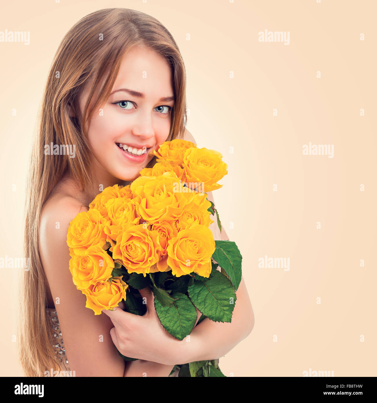 Portrait of a beautiful young woman with a bouquet of yellow roses ...