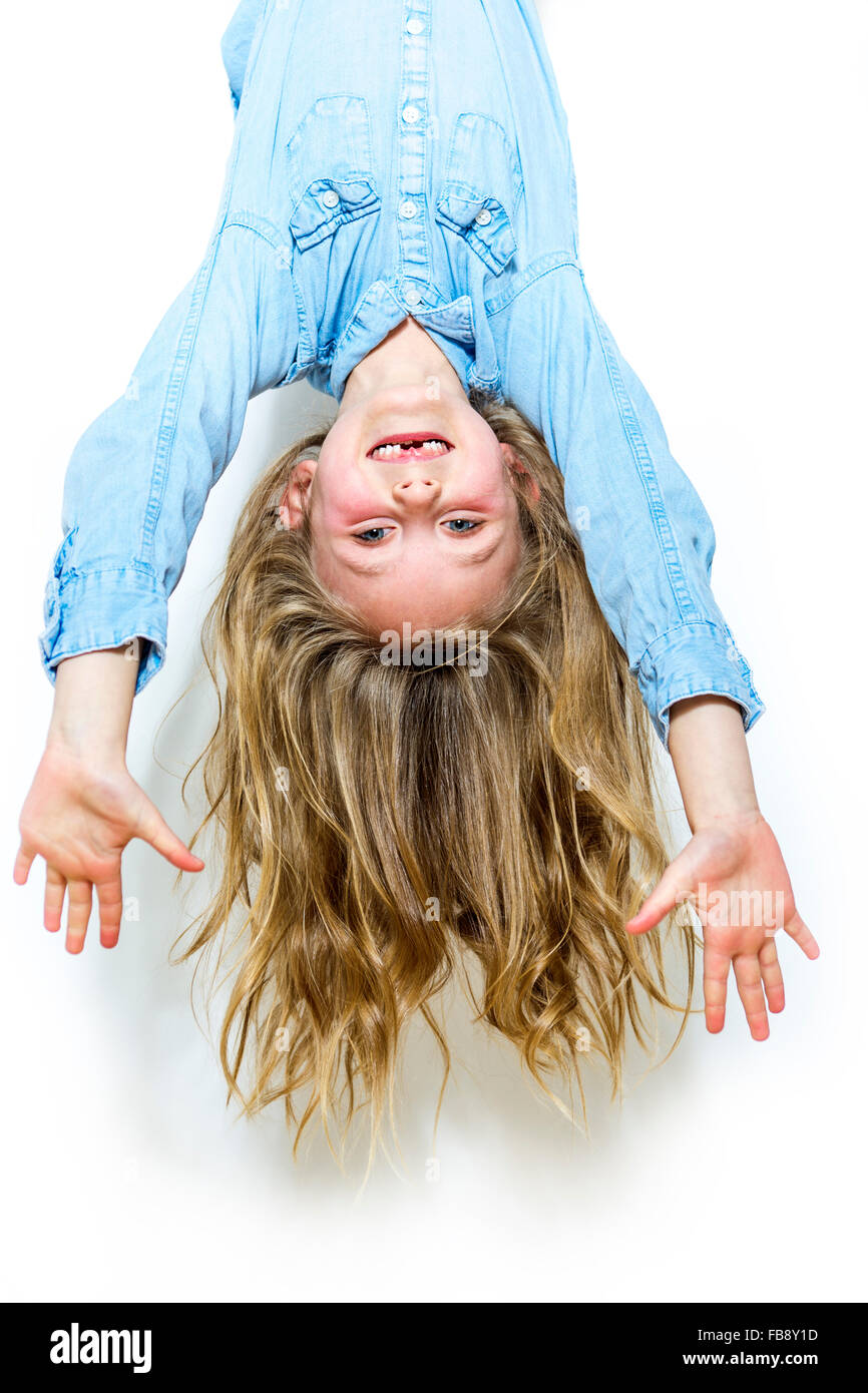 Smiling young girl hanging in front of white background Stock Photo