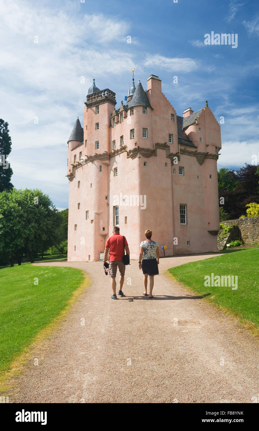 Tourists walking up the driveway towards Craigievar Castle - Aberdeenshire, Scotland. Stock Photo