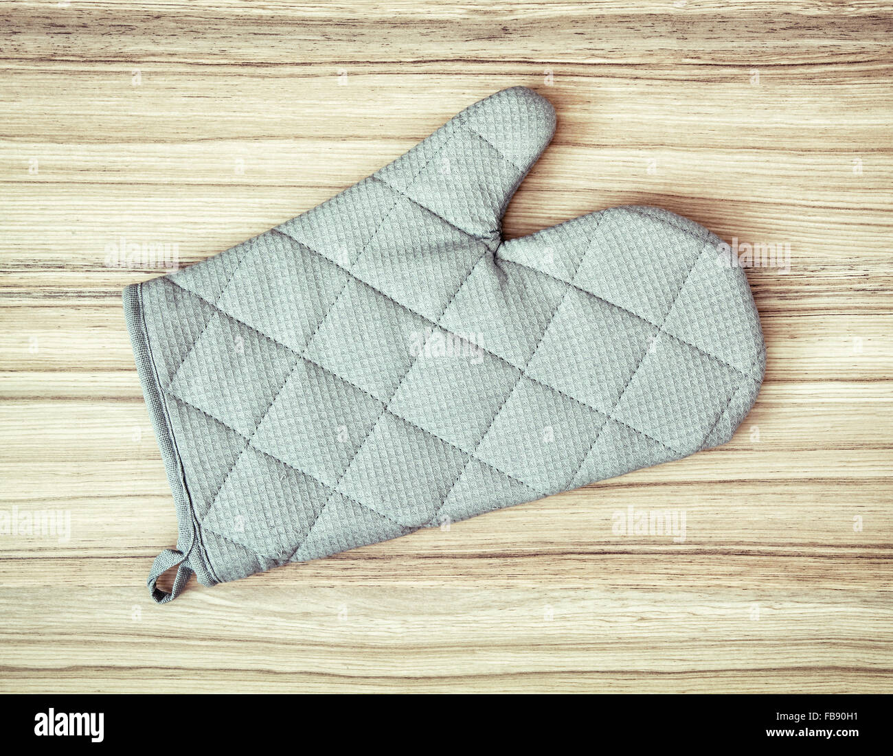 Oven mitt (glove) or potholder on the wooden background. Stock Photo