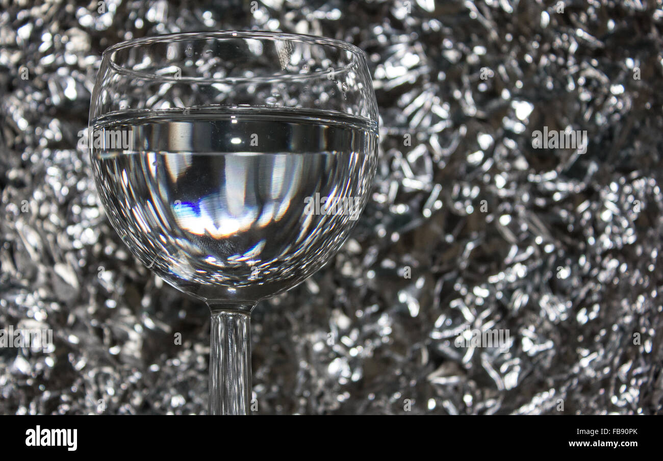 Wine glass on a silver tin foil background. Stock Photo