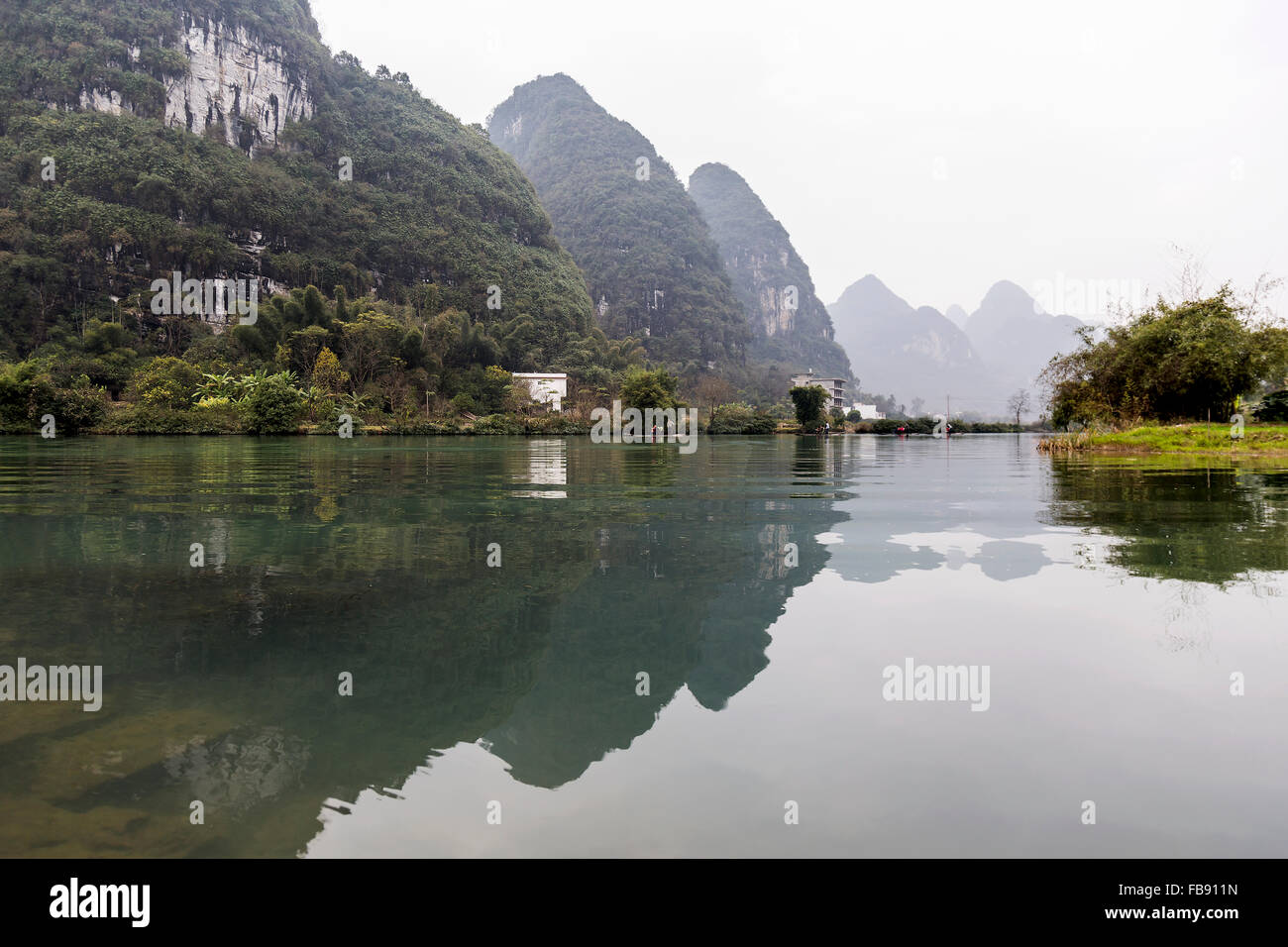 Yulong River, Yangshuo - China. January 2016 - People traveling along the Yulong river on traditional bamboo rafts. Stock Photo