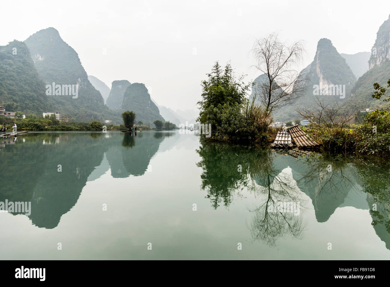 Yulong River, Yangshuo - China. January 2016 - People traveling along the Yulong river on traditional bamboo rafts. Stock Photo