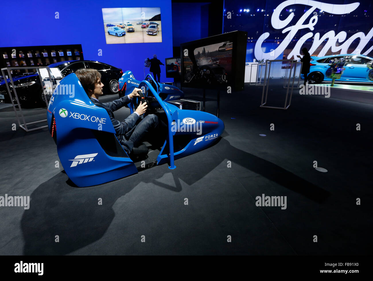 Brussels. 12th Jan, 2016. Photo taken on Jan. 12, 2016 shows a man playing a sports car simulator at Ford booth during the media day of the 94th European Motor Show in Brussels, capital of Belgium. Credit:  Ye Pingfan/Xinhua/Alamy Live News Stock Photo