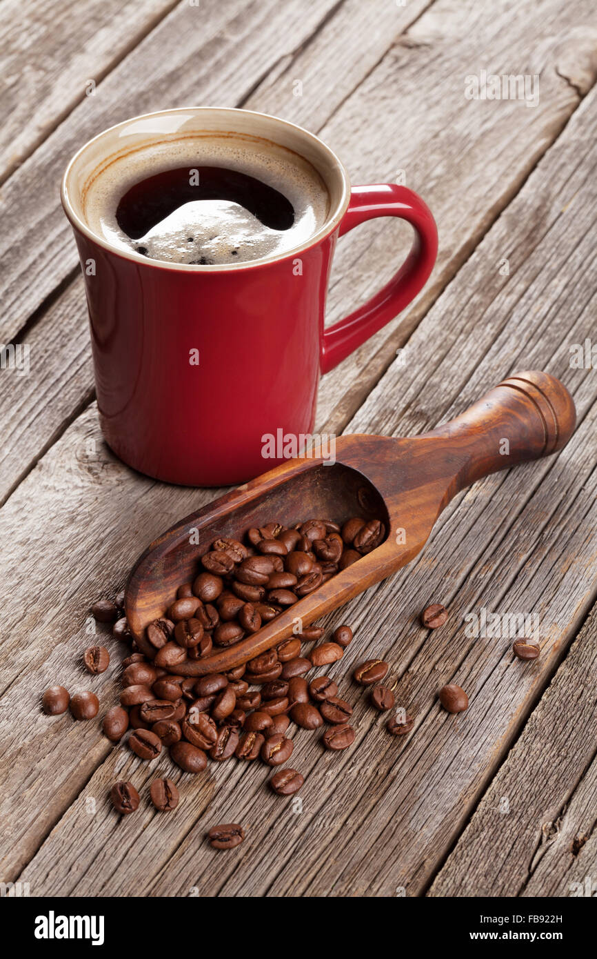 Coffee cup and beans on wooden table Stock Photo - Alamy