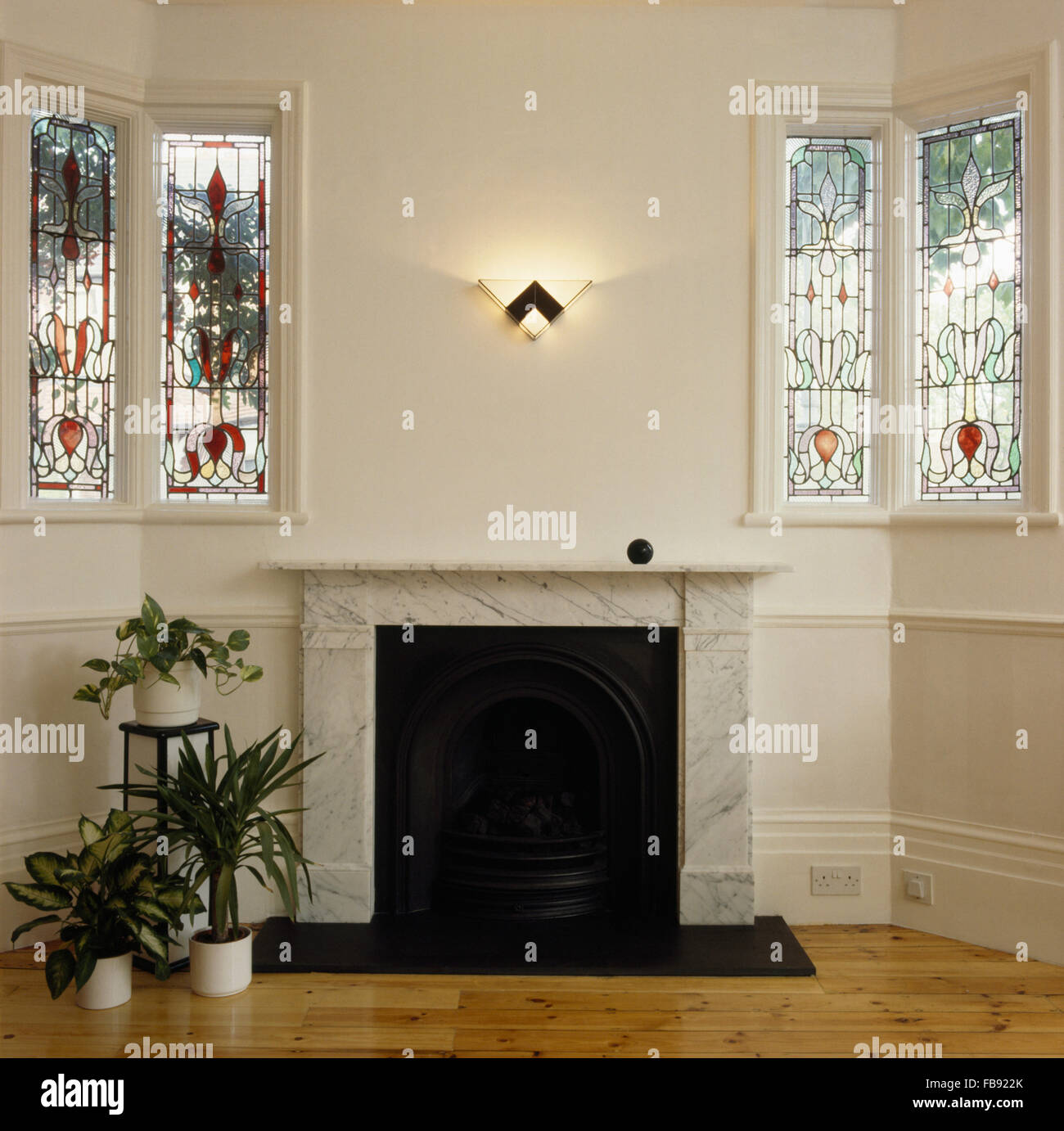 Stained glass windows either side of marble fireplace Stock Photo Alamy