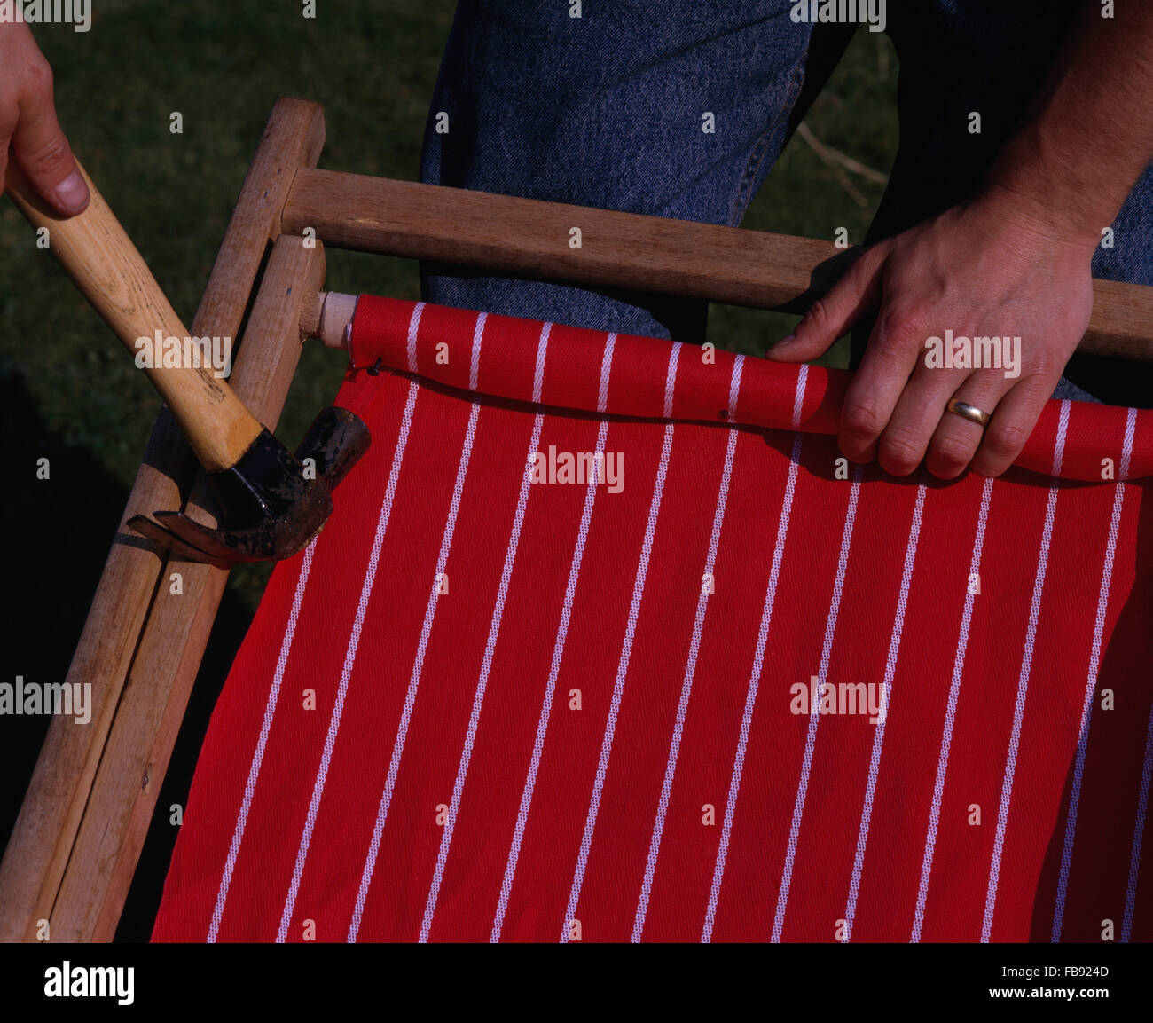 Close Up Of Hands Replacing Canvas On Deck Chair Stock Photo