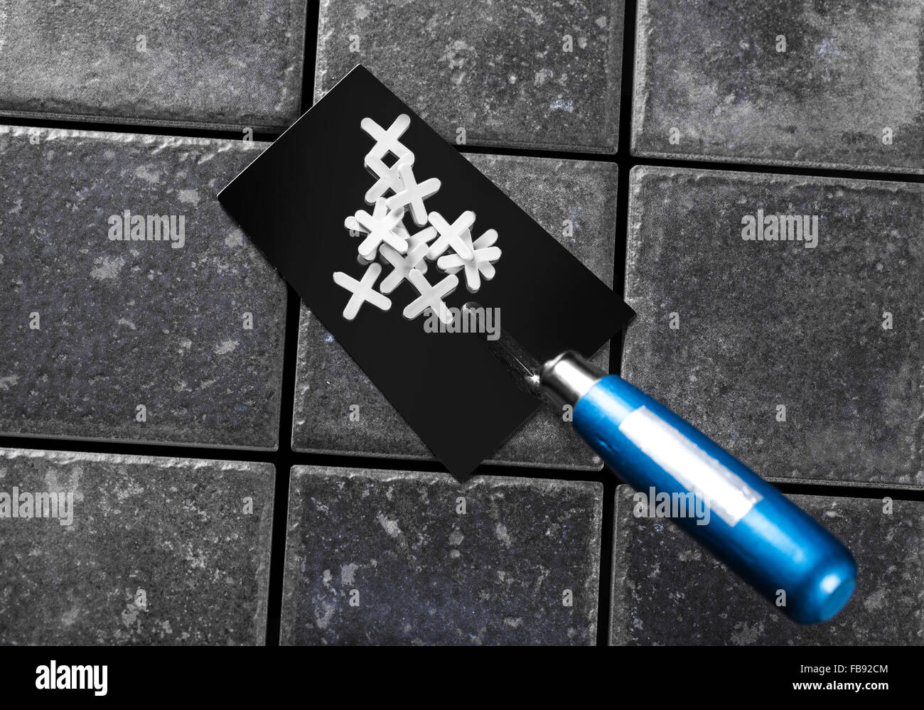 the trowel closeup on a background of ceramic tile Stock Photo - Alamy