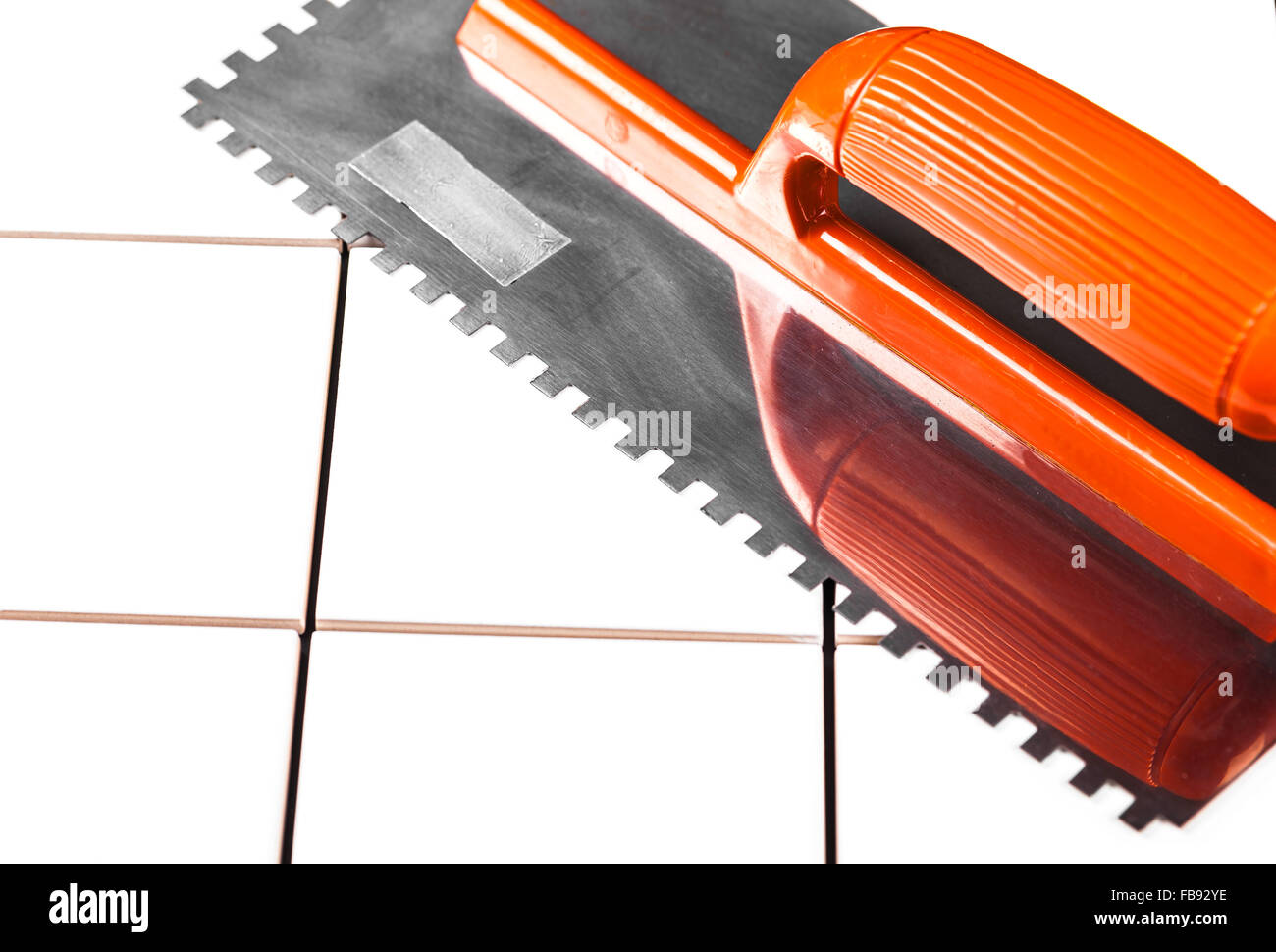 the trowel closeup on a background of ceramic tile Stock Photo - Alamy