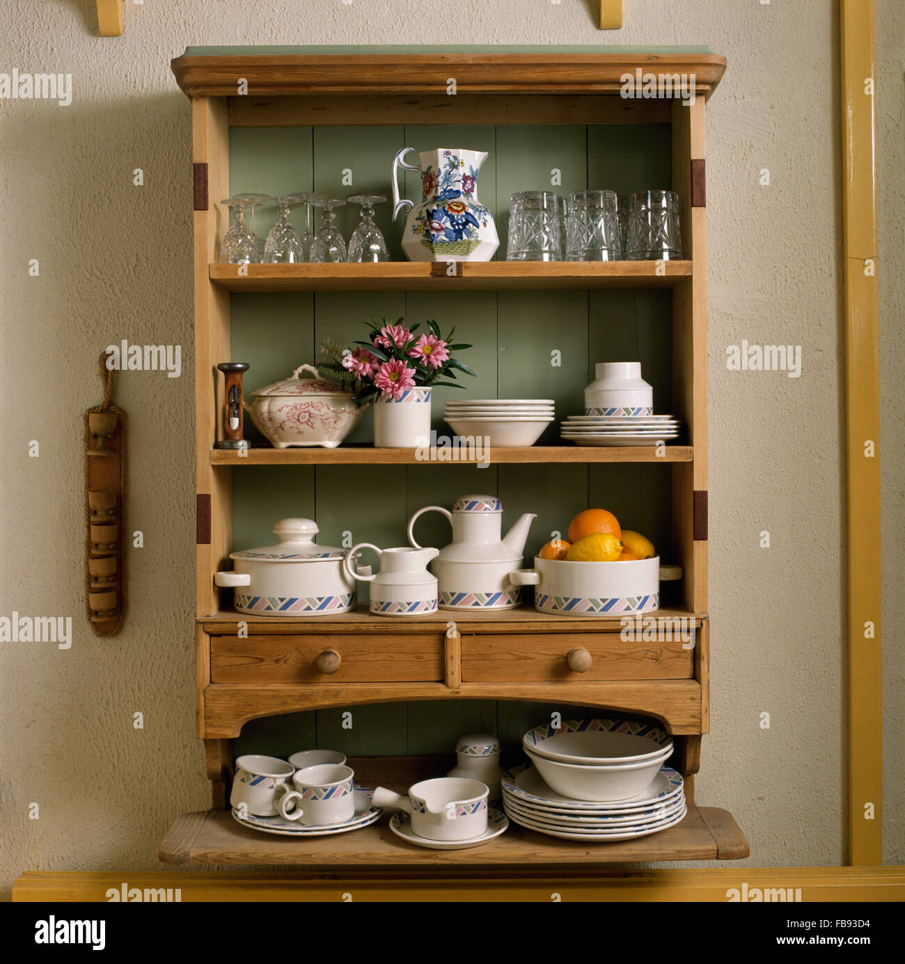 Close-up of small pine wall shelves with glassware and crockery Stock Photo