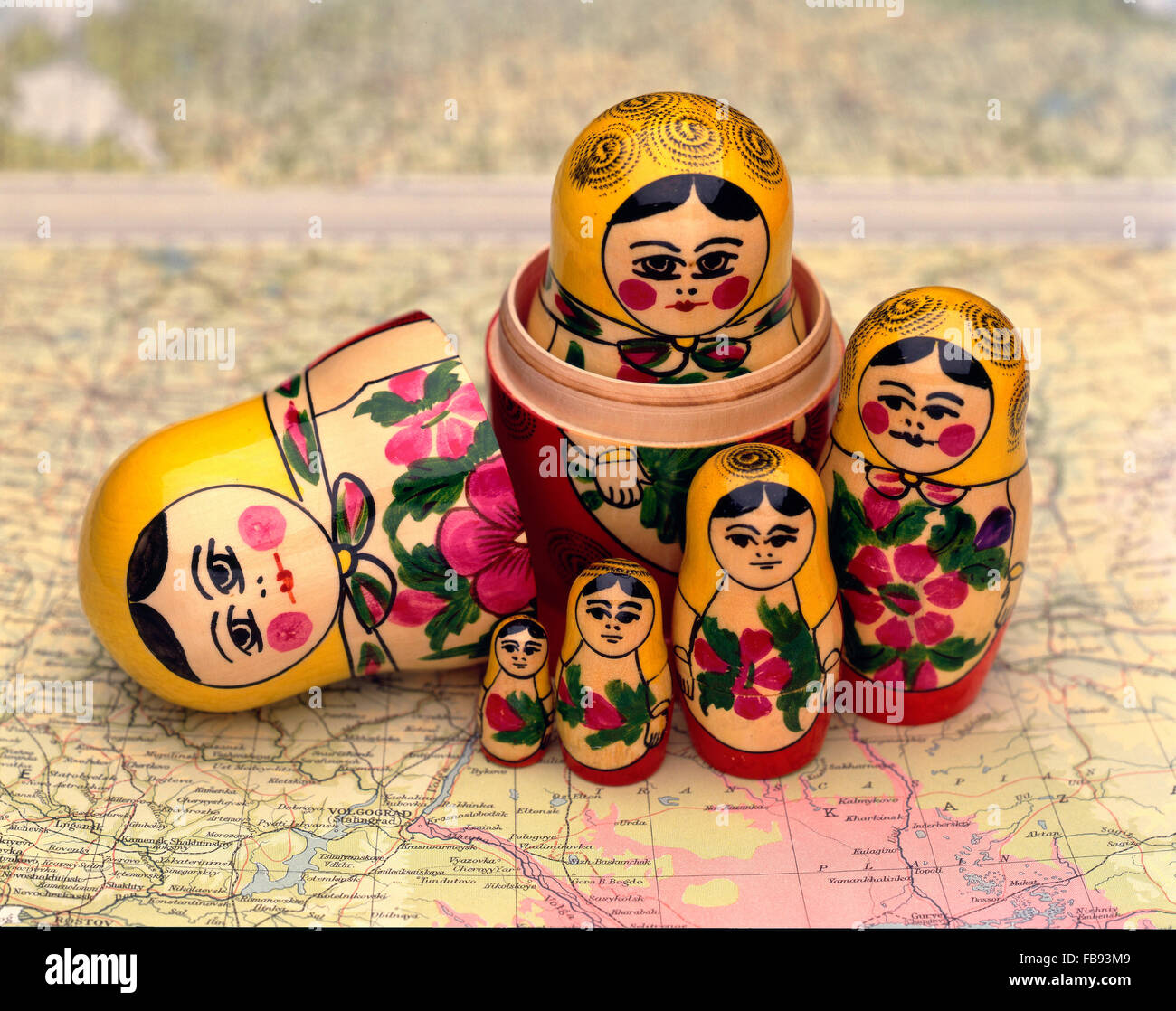 A wooden matryoshka doll, also known as a Russian nesting doll, on a map of Russia Stock Photo