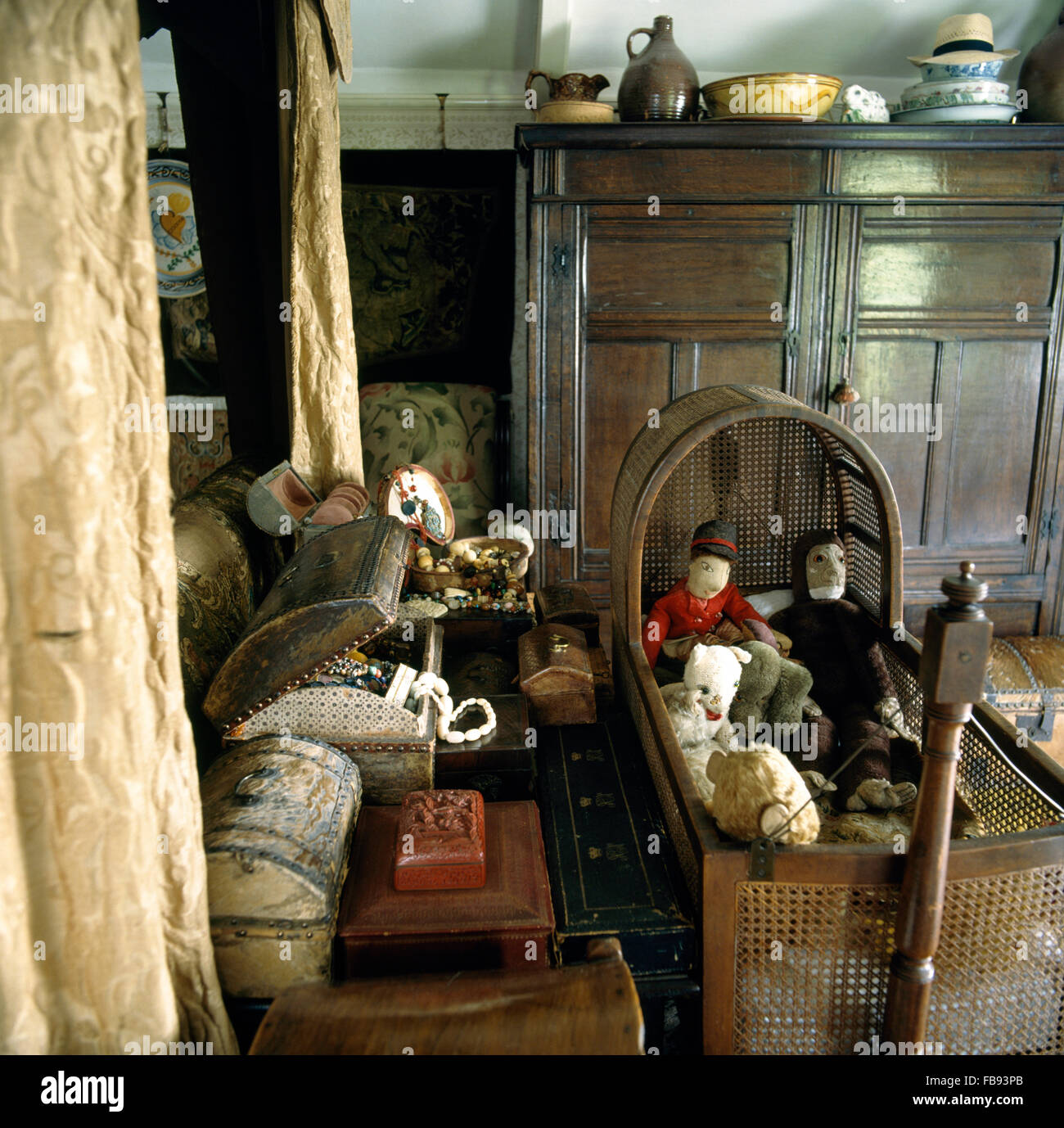Closeup of antique cane rocking cradle in beside four poster bed in