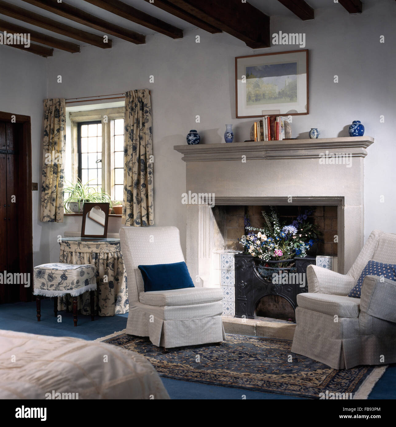 White Chairs Either Side Of Stone Fireplace In A Country Bedroom