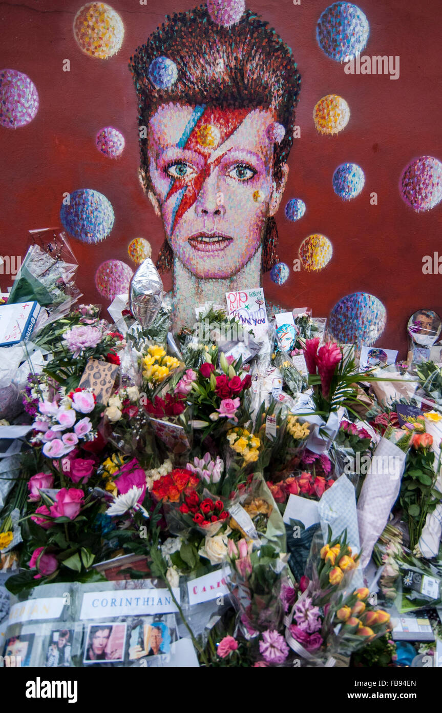London, UK.  12 January 2016.  Fans continue to visit the mural of David Bowie in Brixton to pay their respects and leave tributes following news that the iconic 69 year old singer had died of cancer the previous day.   Credit:  Stephen Chung / Alamy Live News Stock Photo