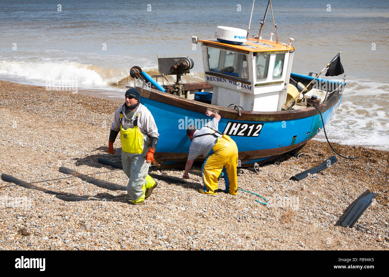 Small inshore fishing boat landing on the beach after six hours at sea