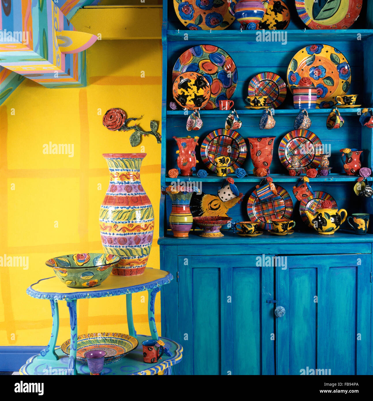 Collection of Mary Rose Young pottery on a bright blue painted dresser
