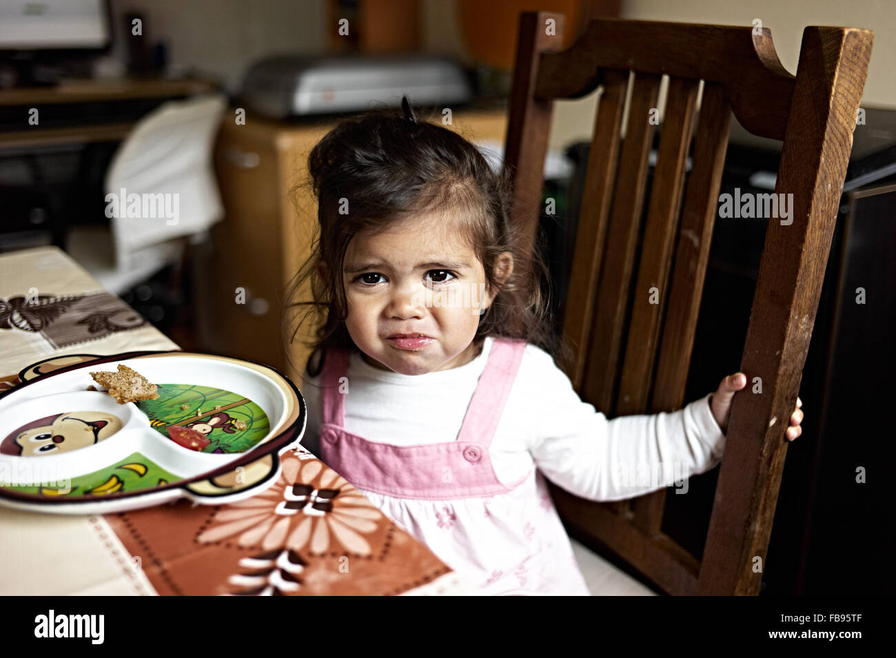 young mixed raced girl sits at table and eats her lunch Stock Photo