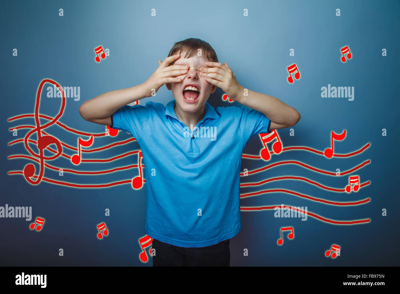 adolescent boy screaming with his eyes closed hands music notes Stock Photo