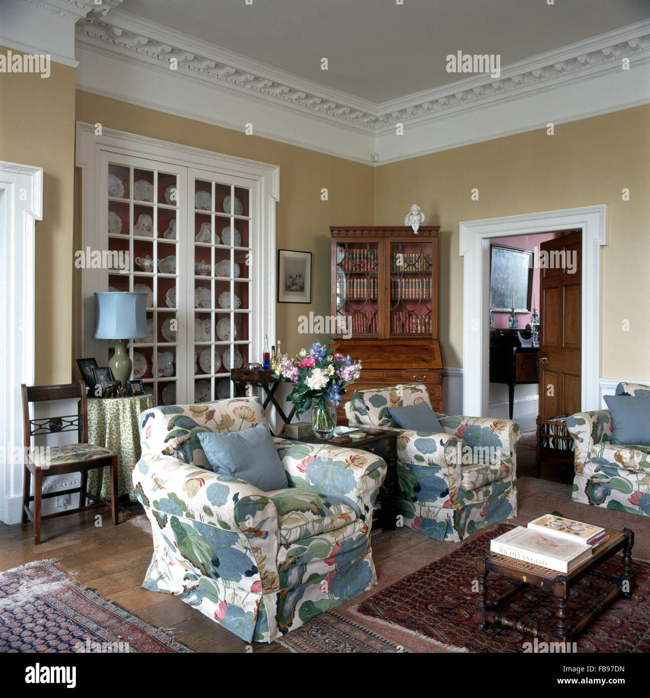 Large floral patterned slip covers on armchairs in dated old fashioned living room Stock Photo