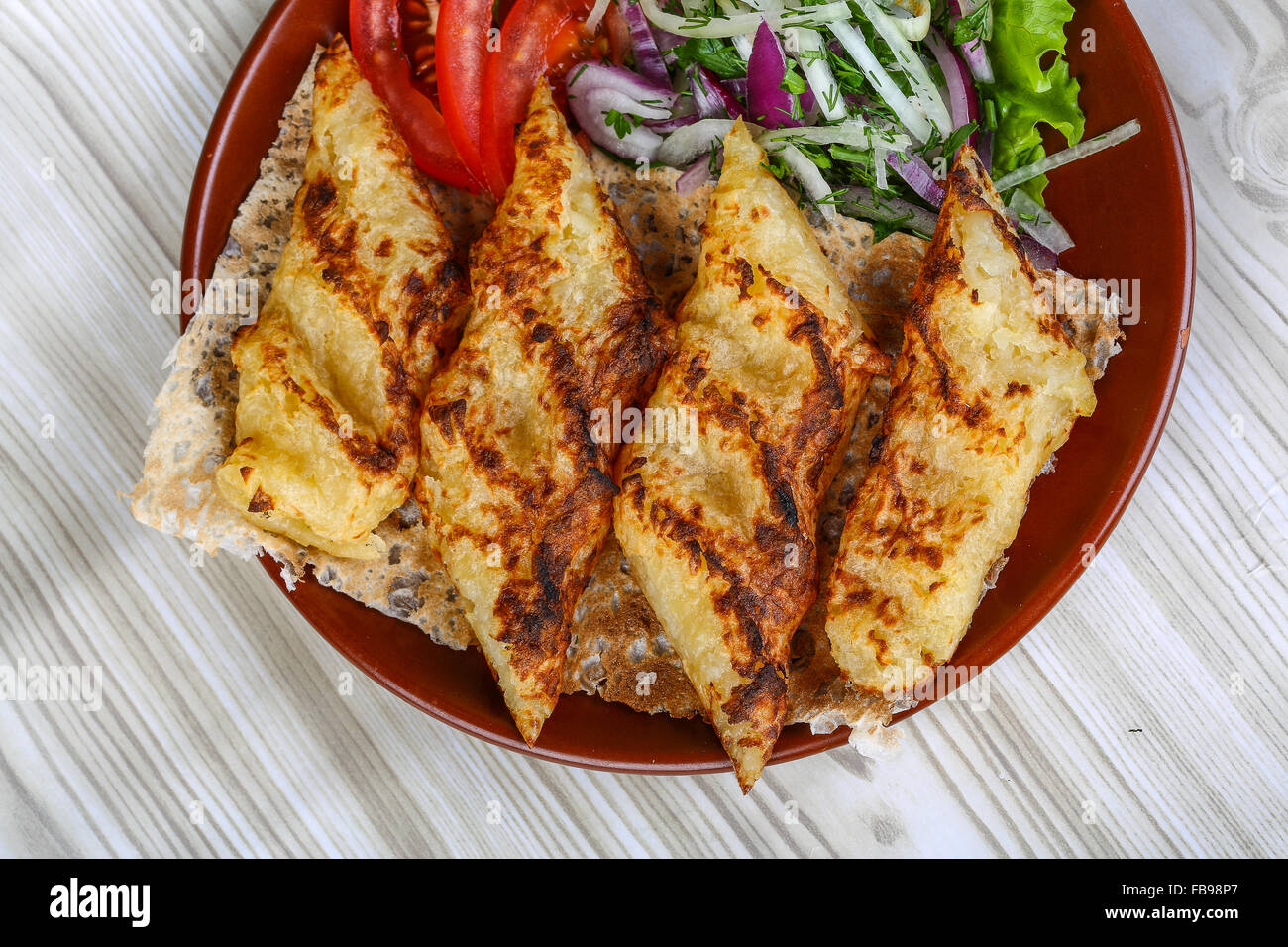 Grilled potato kebab served bread, tomato, salad and onion rings Stock