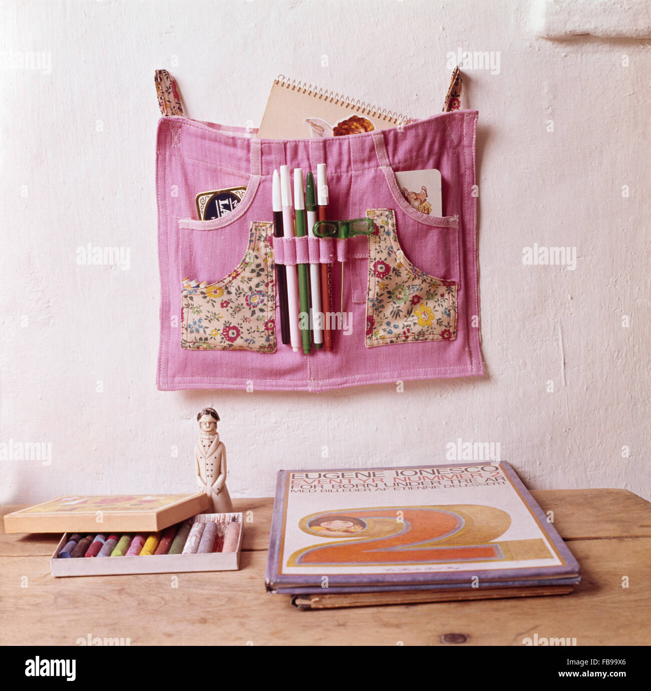Pink denim shorts made into wall storage for pens and notebooks Stock Photo