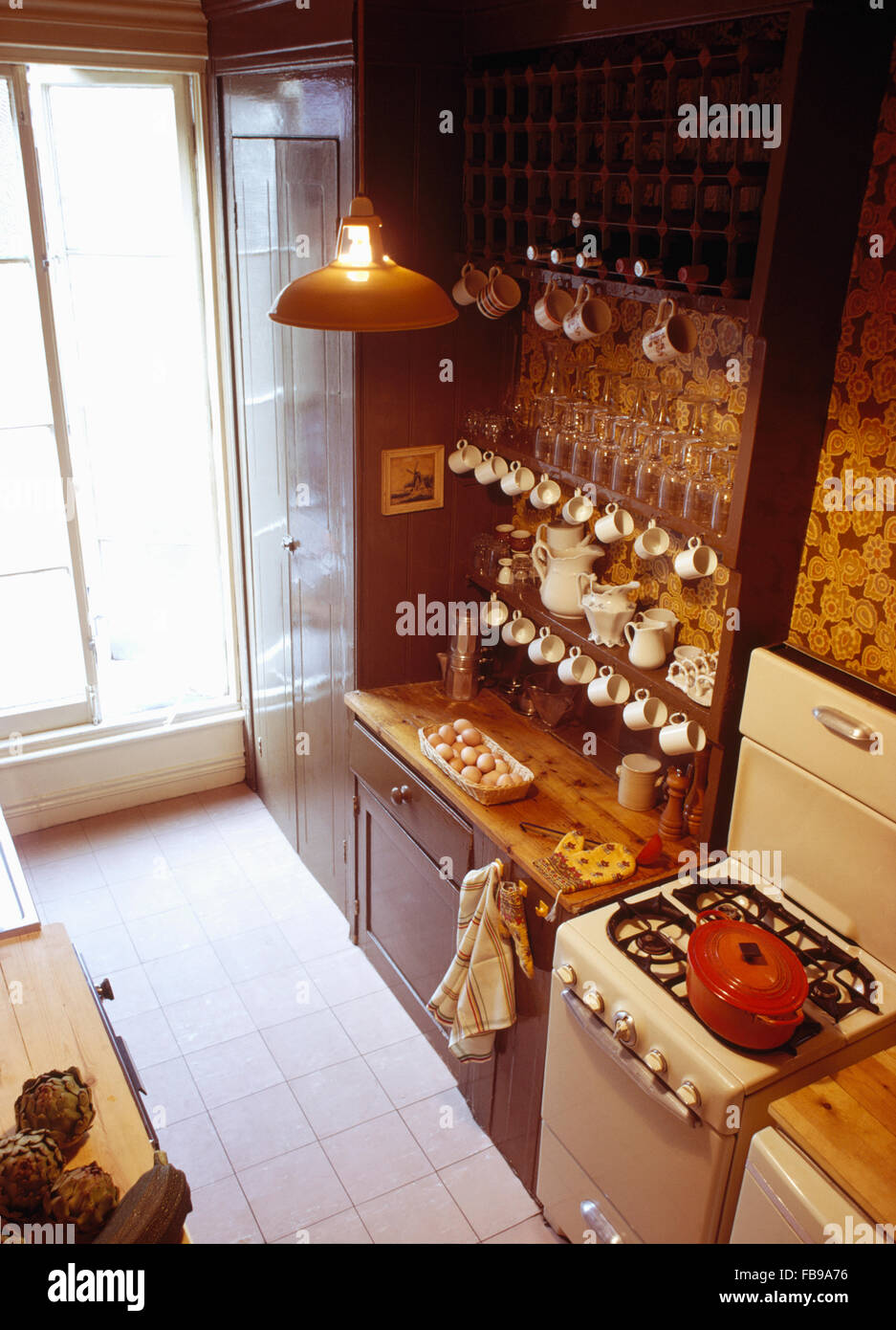 Birdseye view of brown fitted dresser beside gas stove in sixties