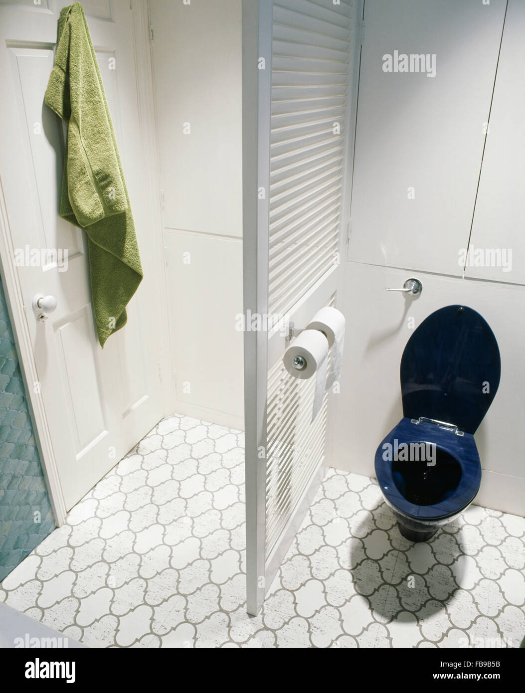 Blue toilet and louvre room divider in seventies bathroom with white tiled  floor Stock Photo - Alamy