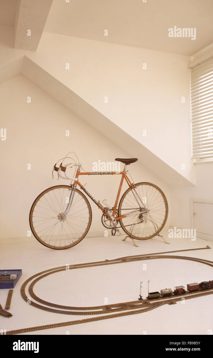 Bicycle and train set in white sixties playroom Stock Photo