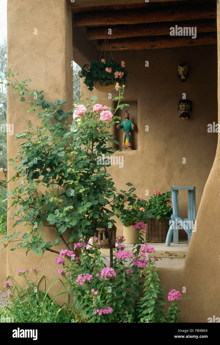 Pink phlox and roses growing in border beside veranda of Mexican villa Stock Photo