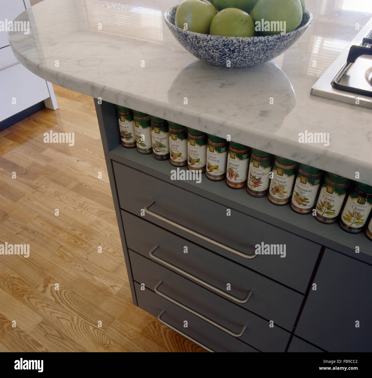 Row of spice jars on alcove shelf above drawers in fitted kitchen unit