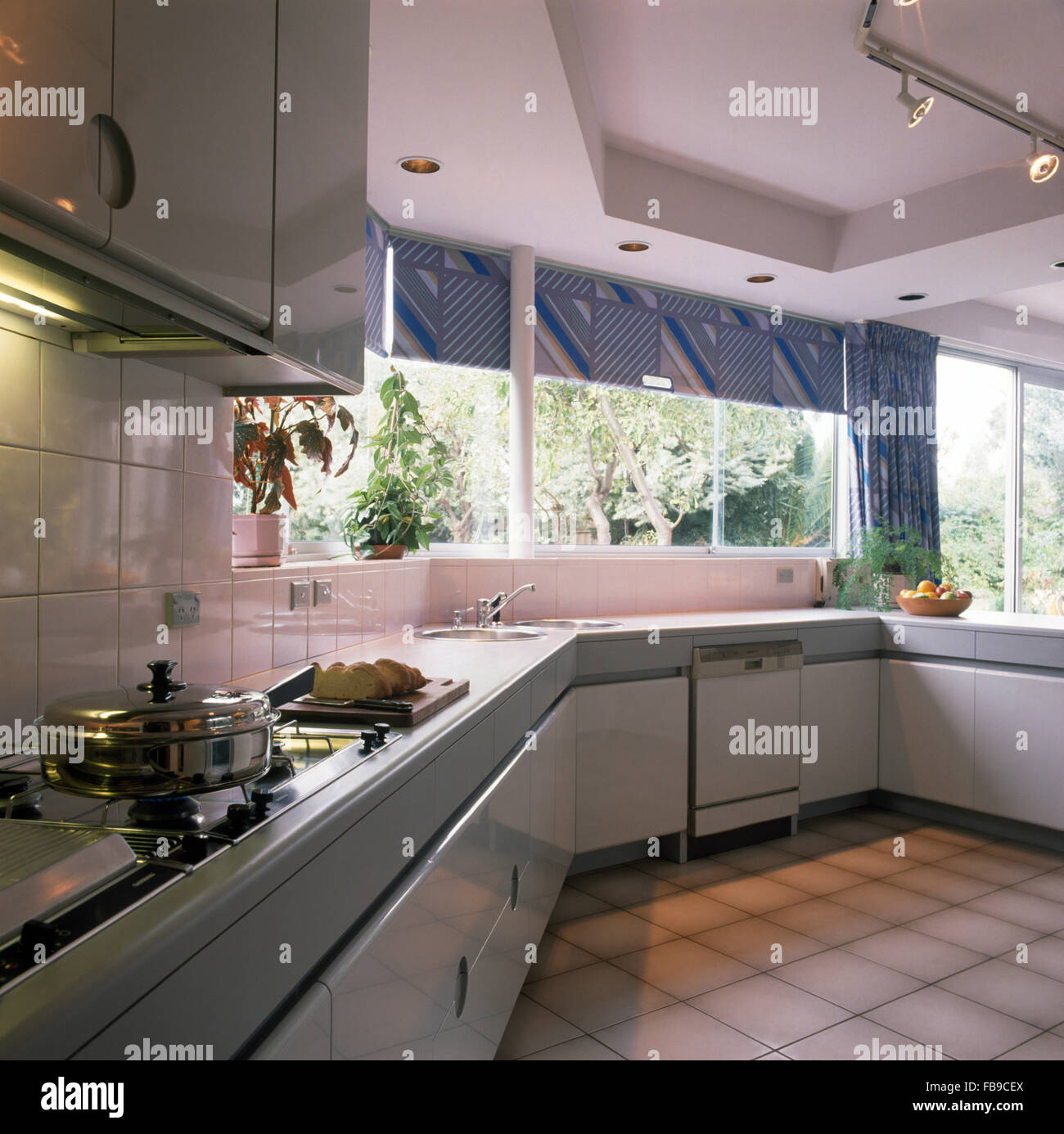 Blue blinds on windows in nineties kitchen with a tiled floor Stock Photo