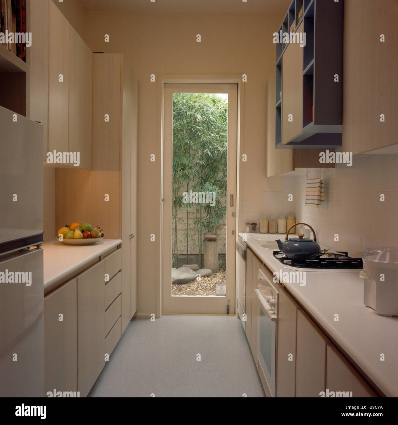Narrow galley kitchen with a glass door to the garden Stock Photo