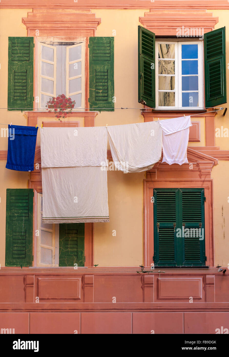 Shutters, fake windows and clothes hanging on a mediterranean facade Stock Photo
