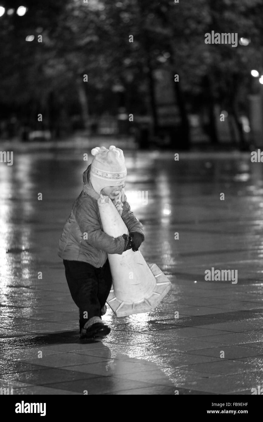 Young girl carrying a cone in the rain on Baku Bulvar, in the capital of Azerbaijan Stock Photo
