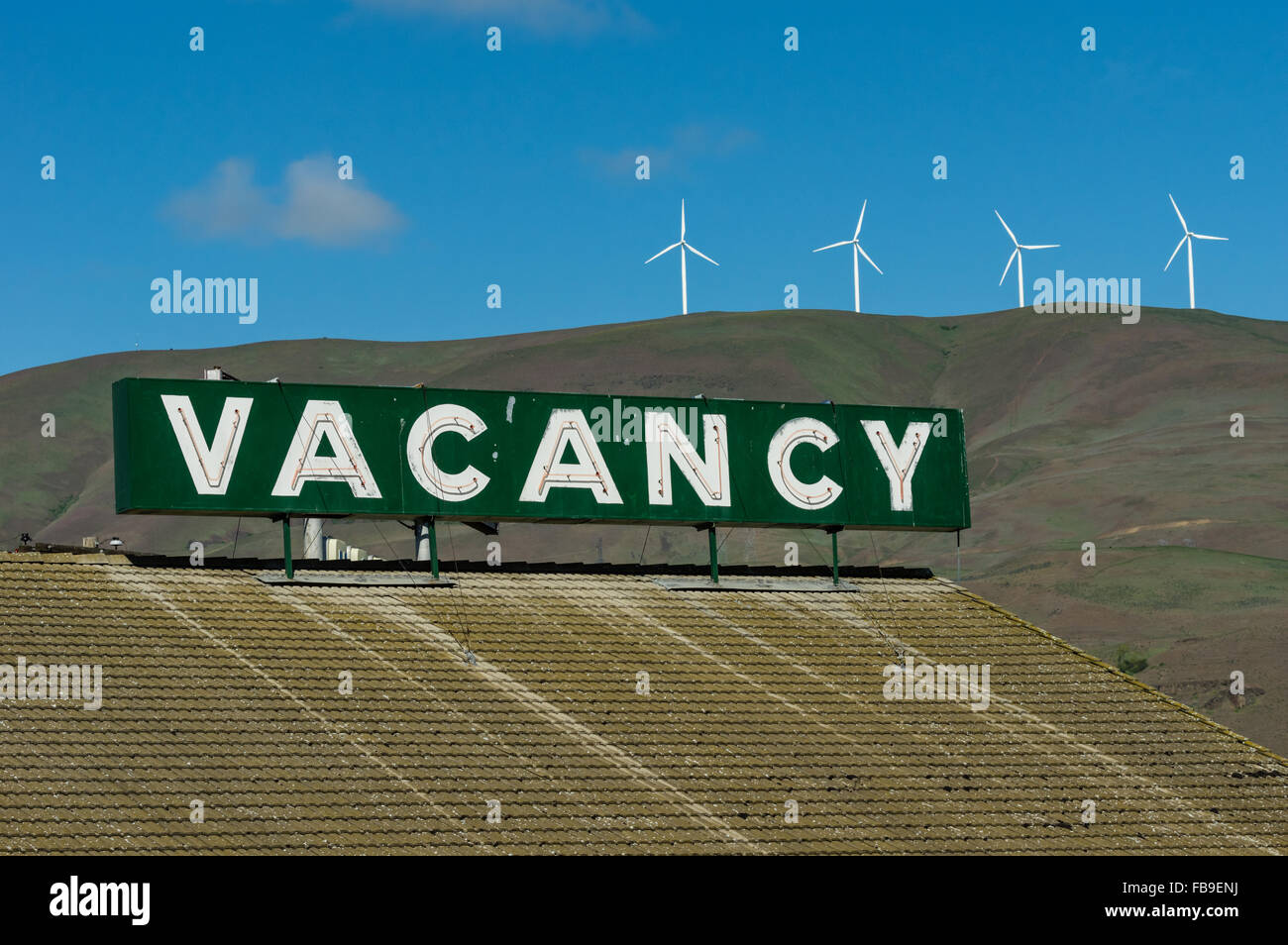Vacancy sign on top of a hotel roof with wind turbines in the background.  Columbia River Gorge, Oregon, USA Stock Photo