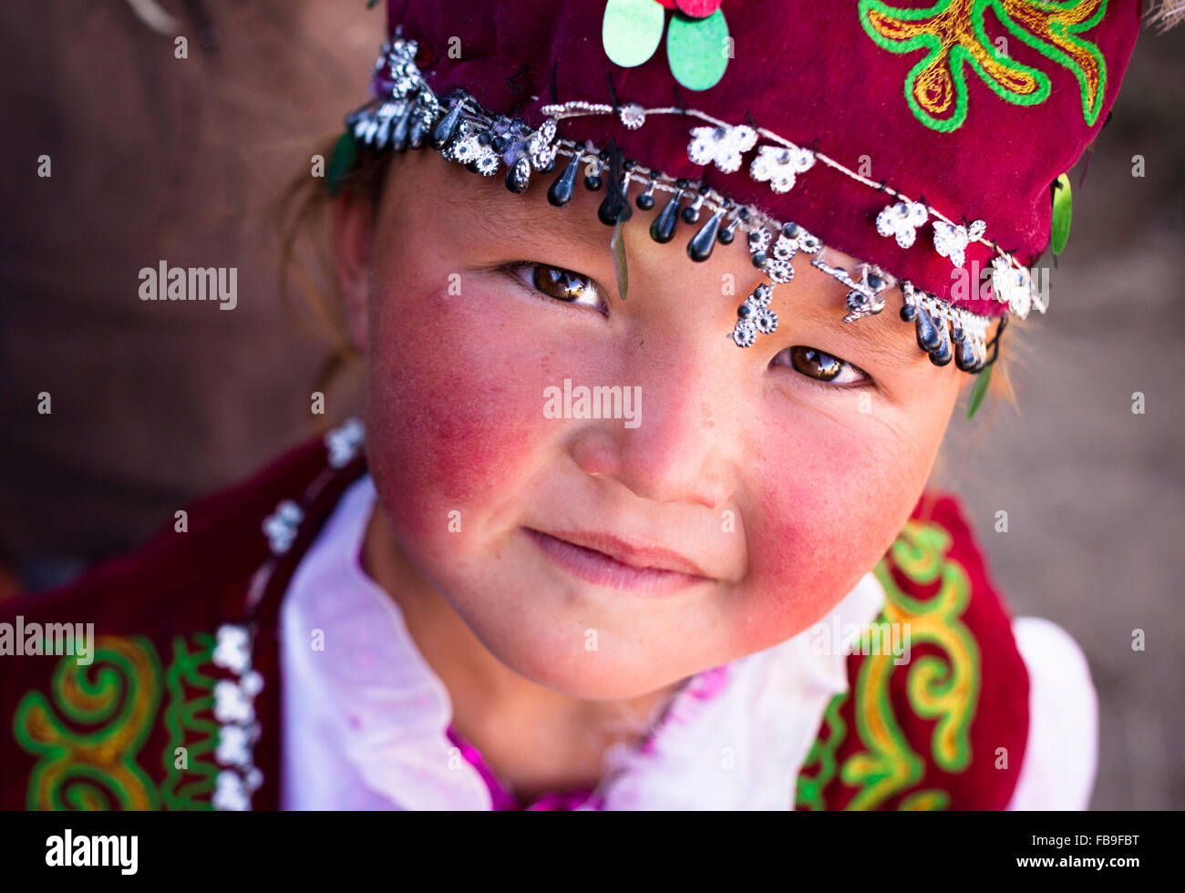 A girl in traditional Kazakh dress from a family of Kazakh eagle hunters near the Tsaast Uul valley, Mongolia. Stock Photo