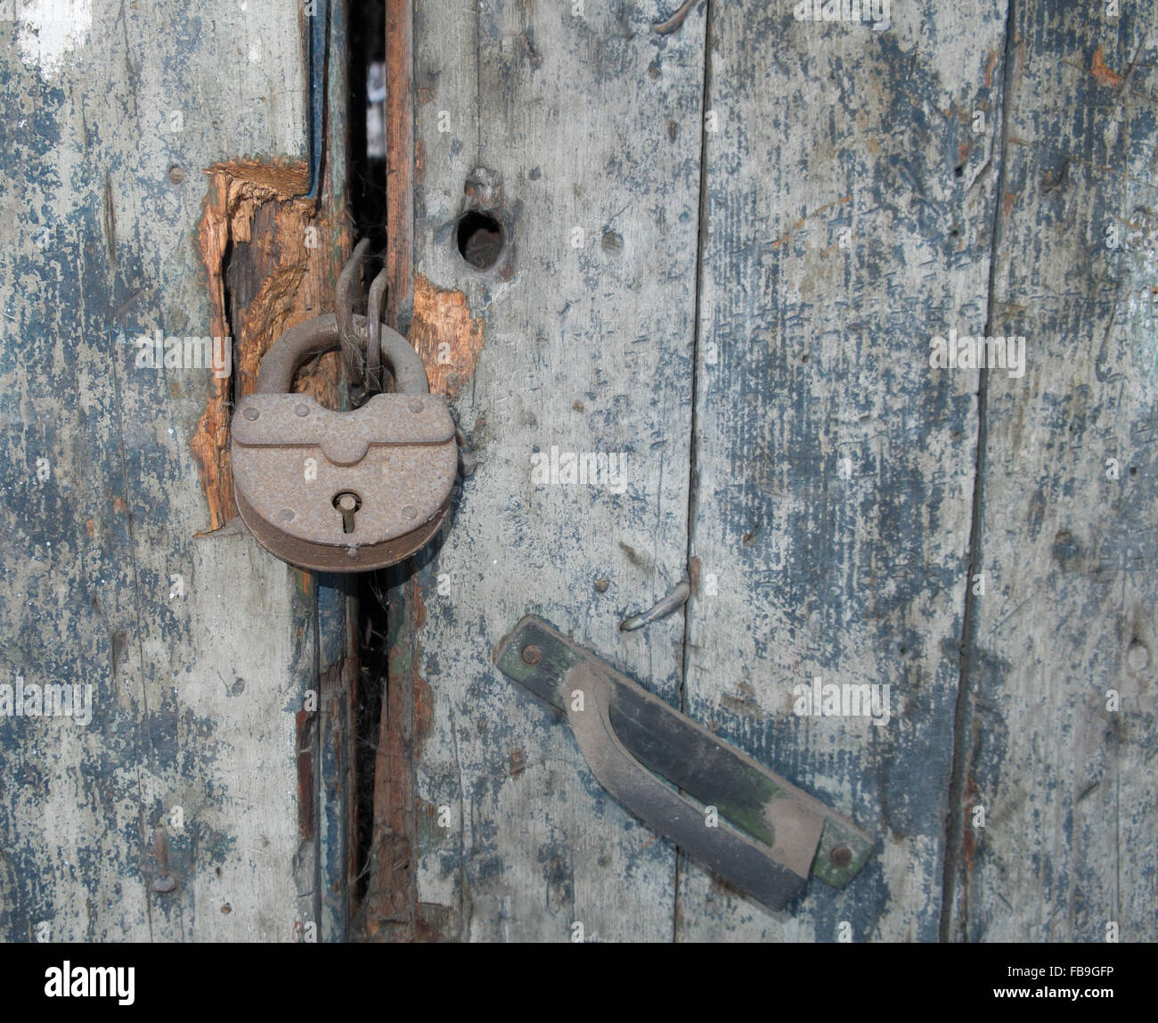 Old rusty metal padlock on the shabby wooden door Stock Photo - Alamy