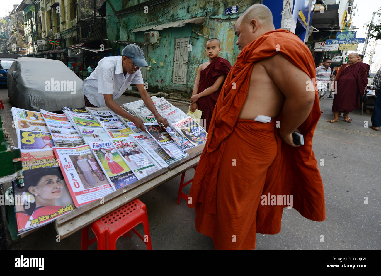 Reading the latest headlines at a newsstand in Yangon, Myanmar. Stock Photo